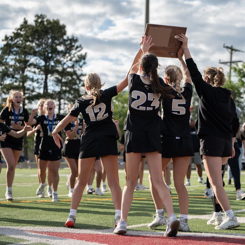 Andover High School girls lacrosse team hoisting section championship trophy