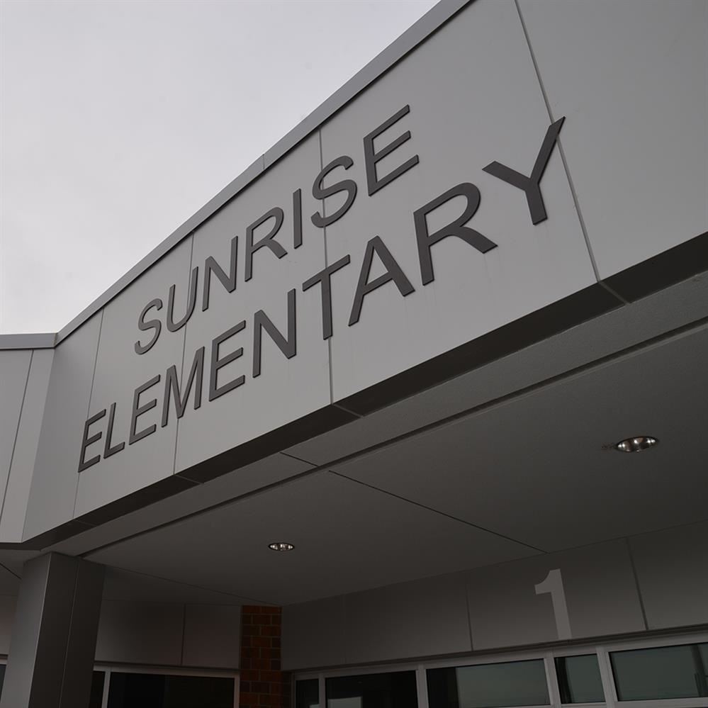 Sunrise Elementary sign on front of school reading school name