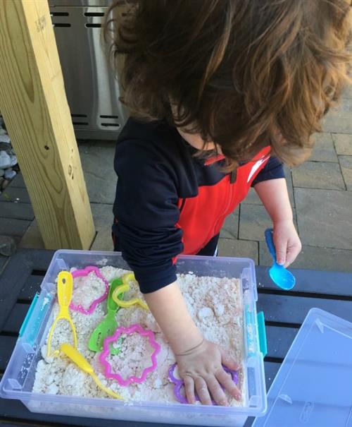 Young child playing with cloud dough