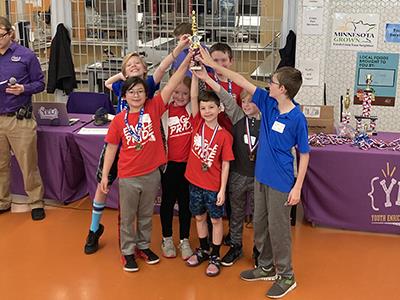 students in a group holding up trophy