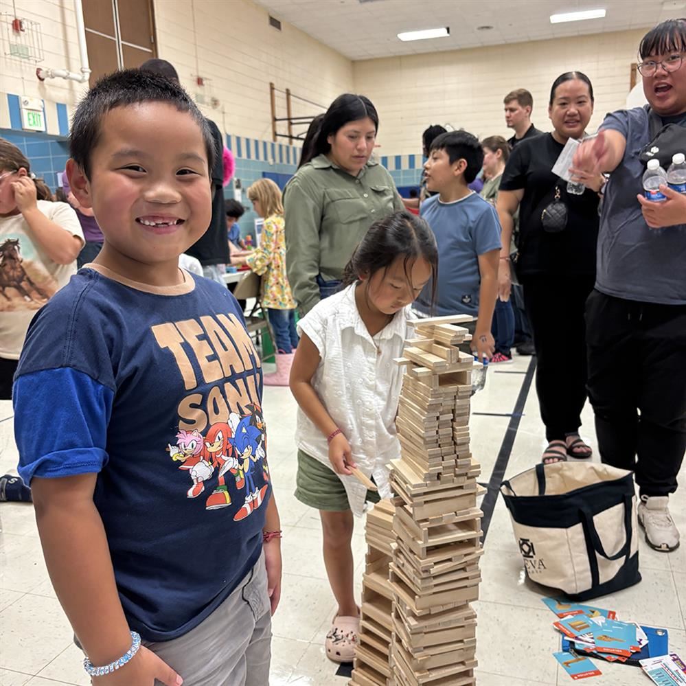  Student smiling next to project at family engagement night