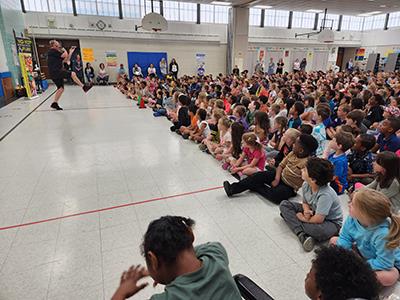 students look on, as Dave performs a trick