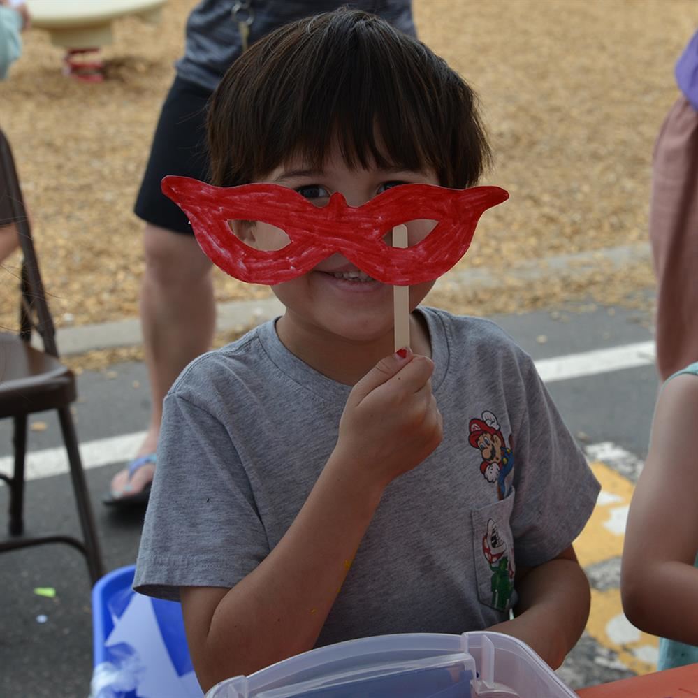  student holding up mask to his face.