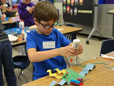 boy using glue on paper
