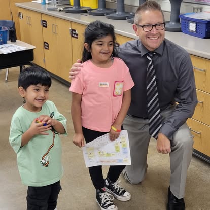 Madison principal Paul Anderson smiling with two students