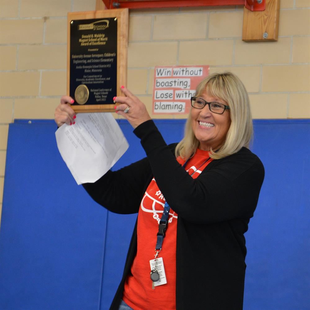  Principal Diedre Bloemers holding up plaque 
