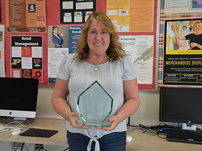 Kathy Vaughn in her classroom with her award
