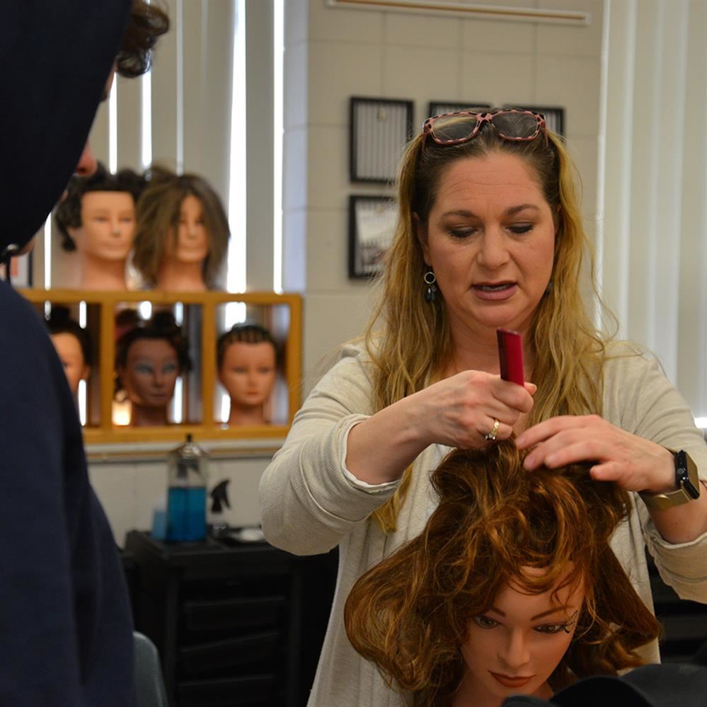  Kristin Shively demonstrates a hair technique on a mannequin 
