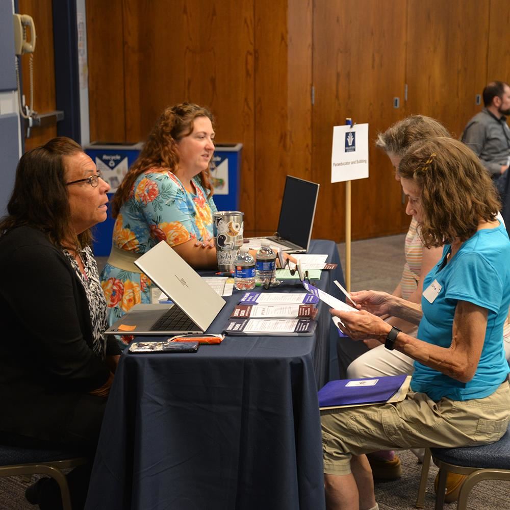 Job seekers speaking with district staff at a past hiring event