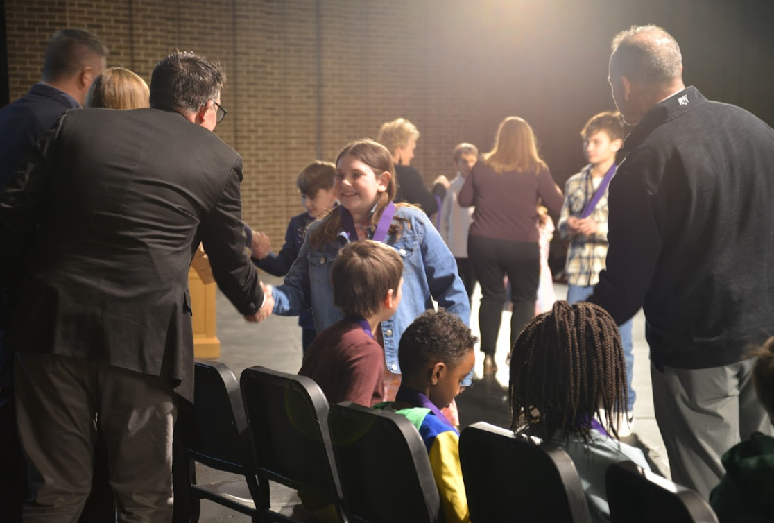 Student receives award shakes hands