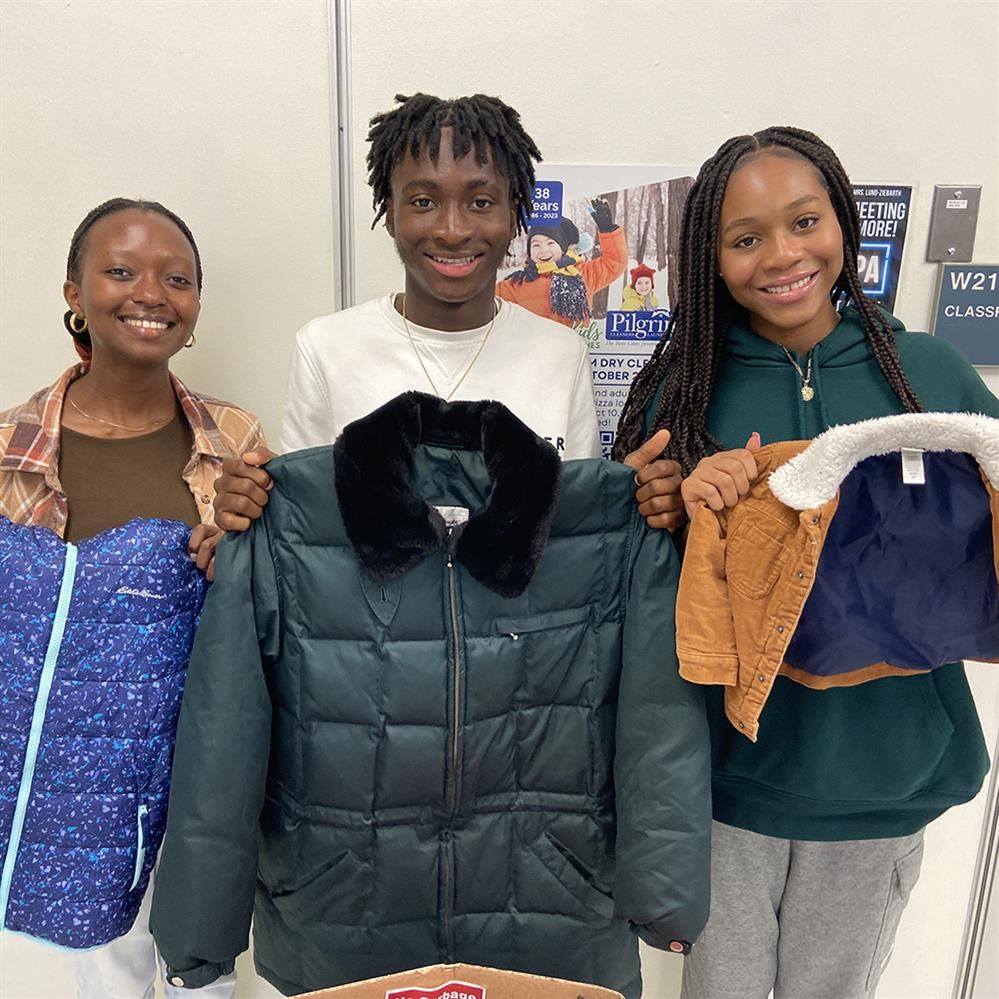 three students holding kids' coats
