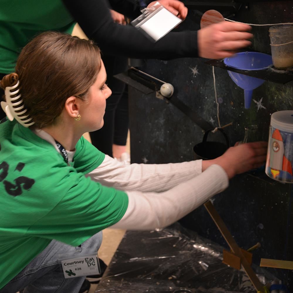  girl setting up portion of the machine 