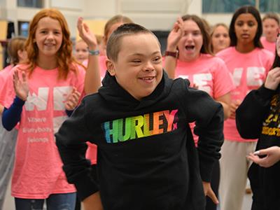 student dancing with students cheering in the background
