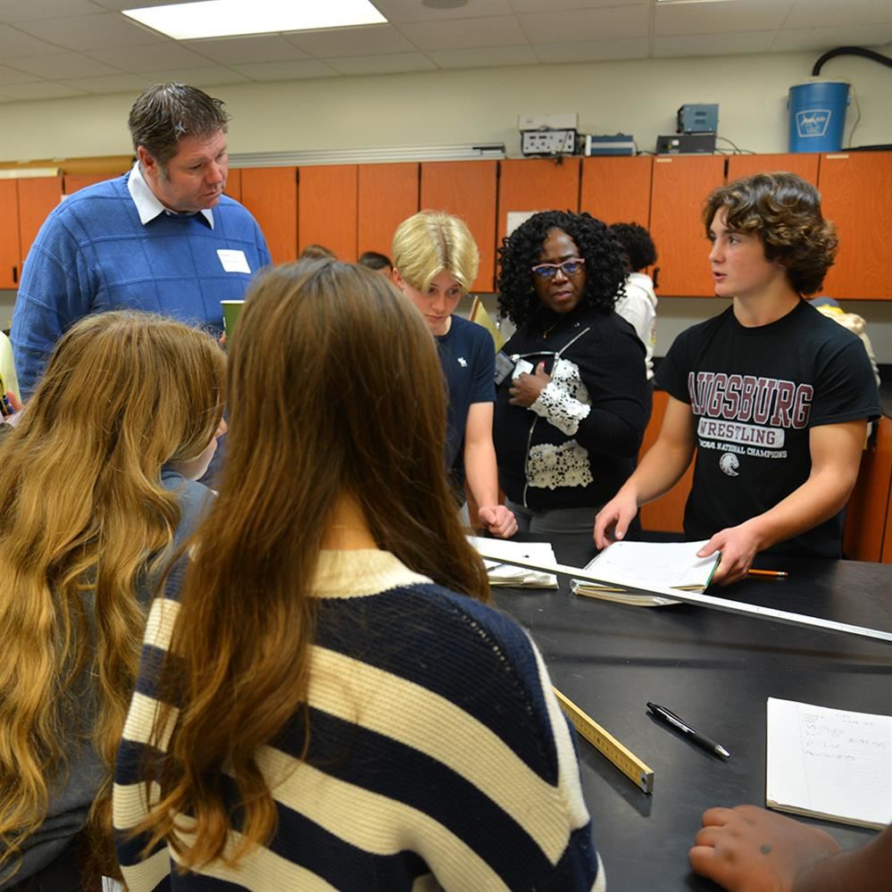  students and visitors interacting in a science room