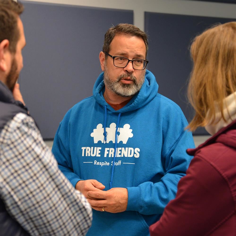  person talking with two other people