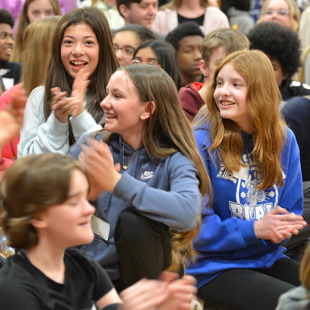 students clapping and smiling 