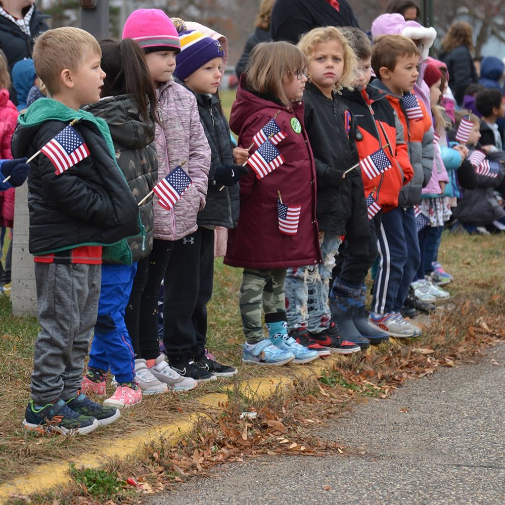  kids holding small American flags 