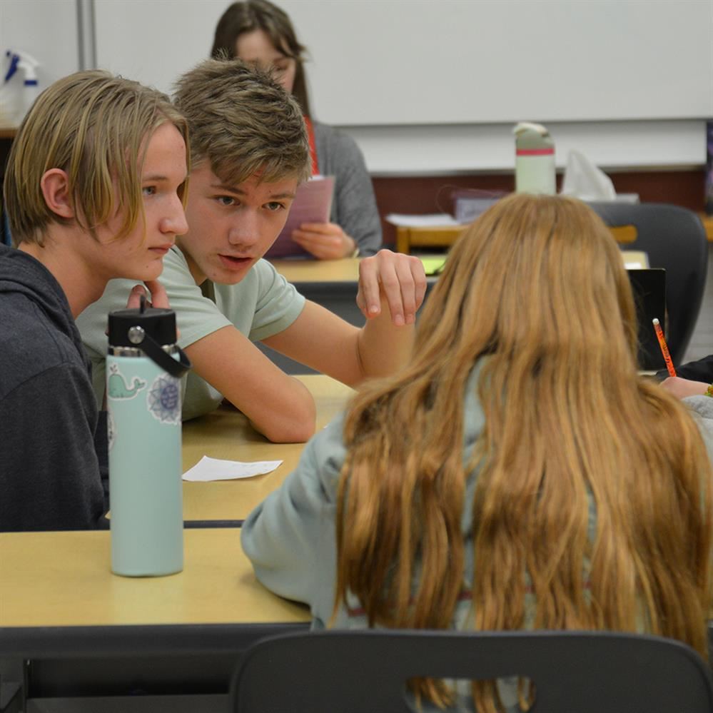  students talking to one another at a table