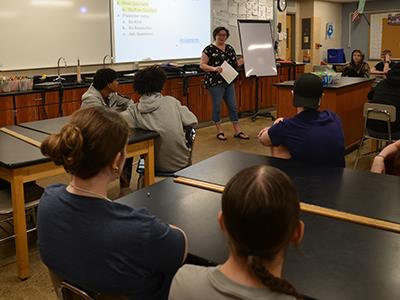 Erin at the front of the class talking to students