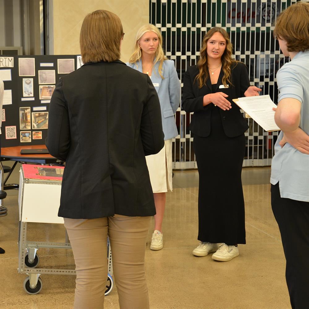  students presenting their project to two reviewers 