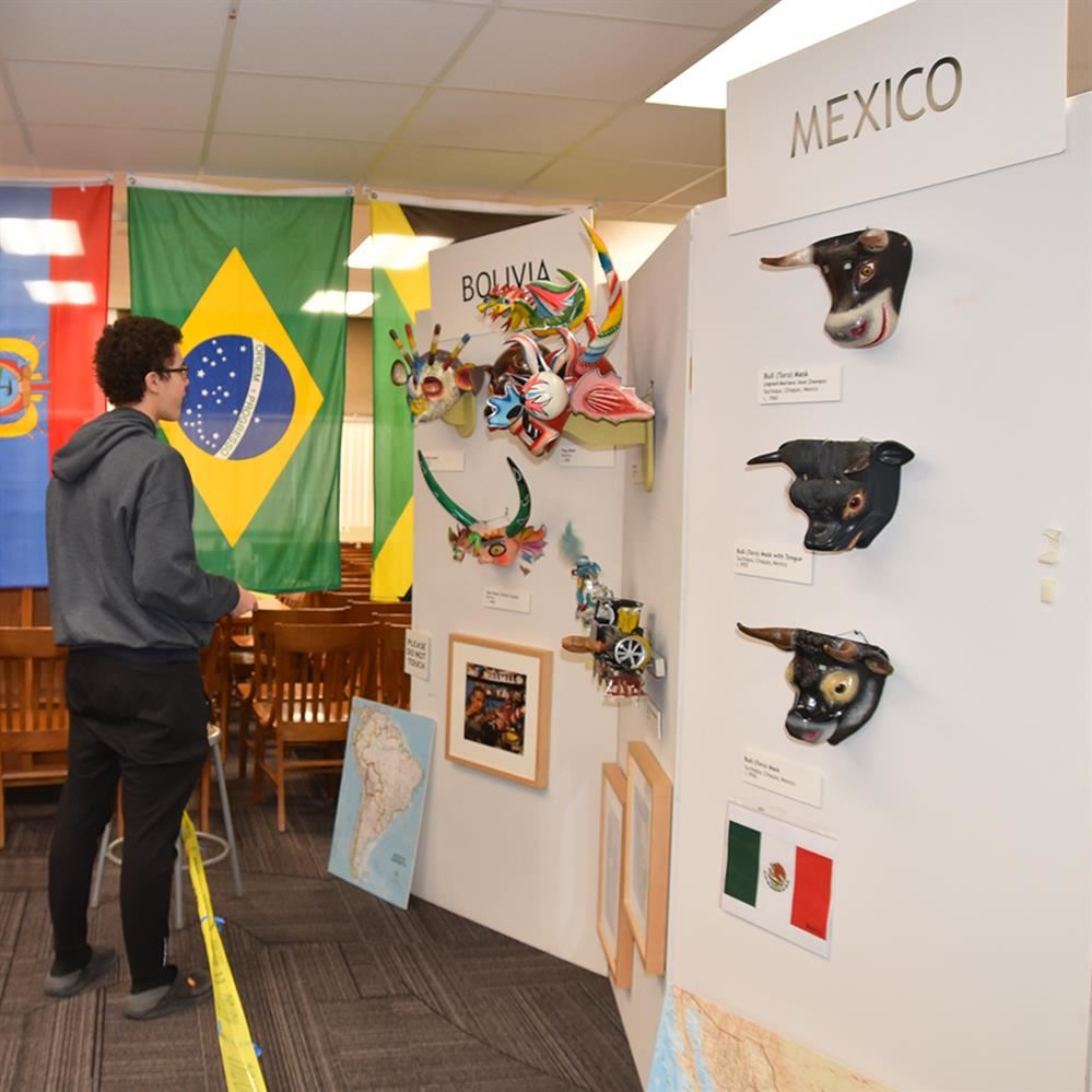  student looking at masks from other countries