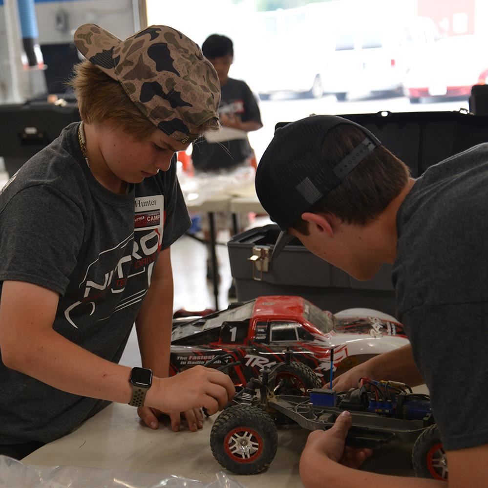  students working on a car together