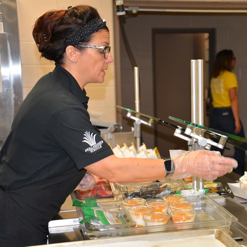  Child nutrition staff member serving a meal