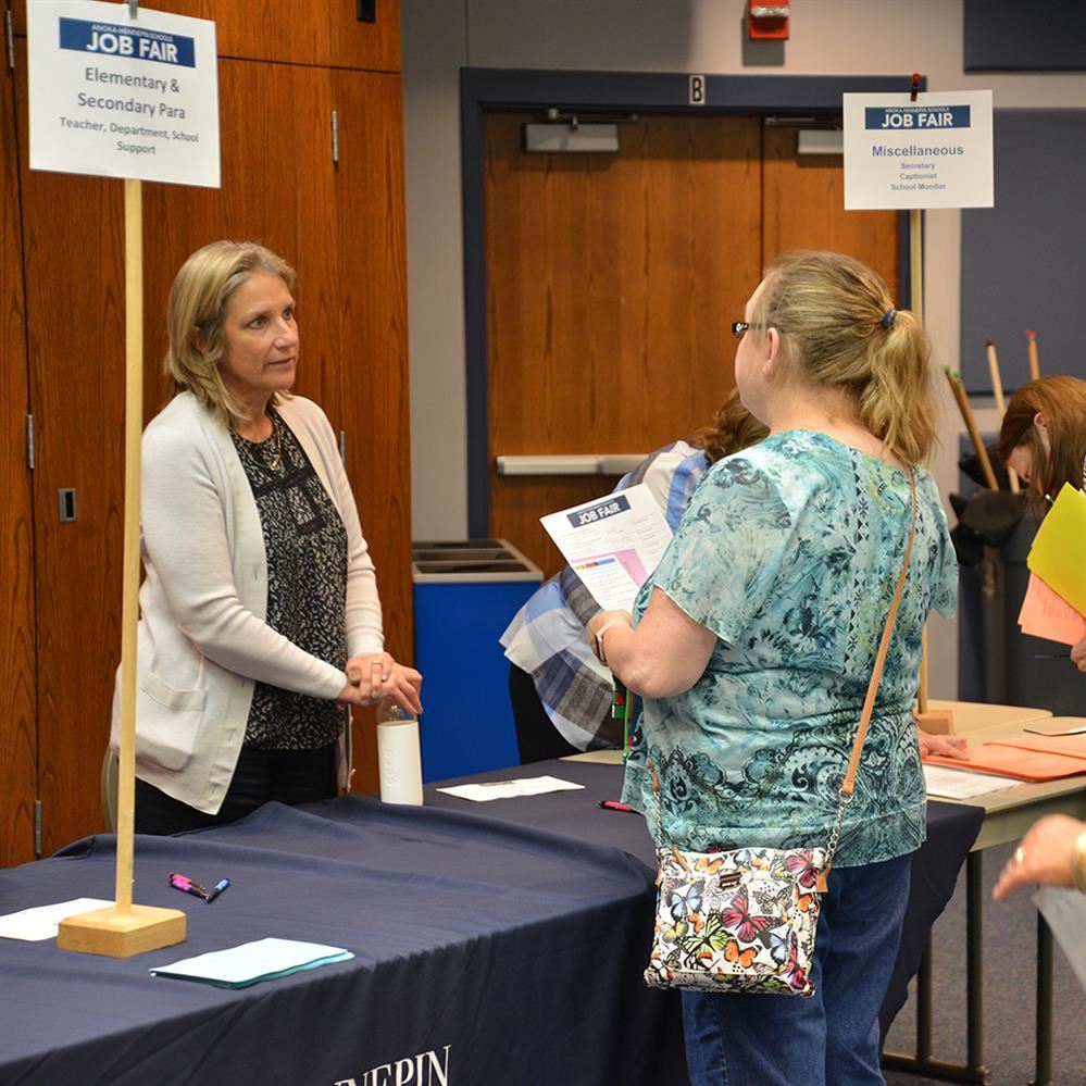 Hiring manager talking with an attendee at a past hiring event