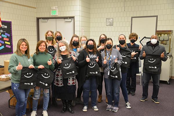 District staff joins Thumbs Up non-profit to stuff cheer bags for students