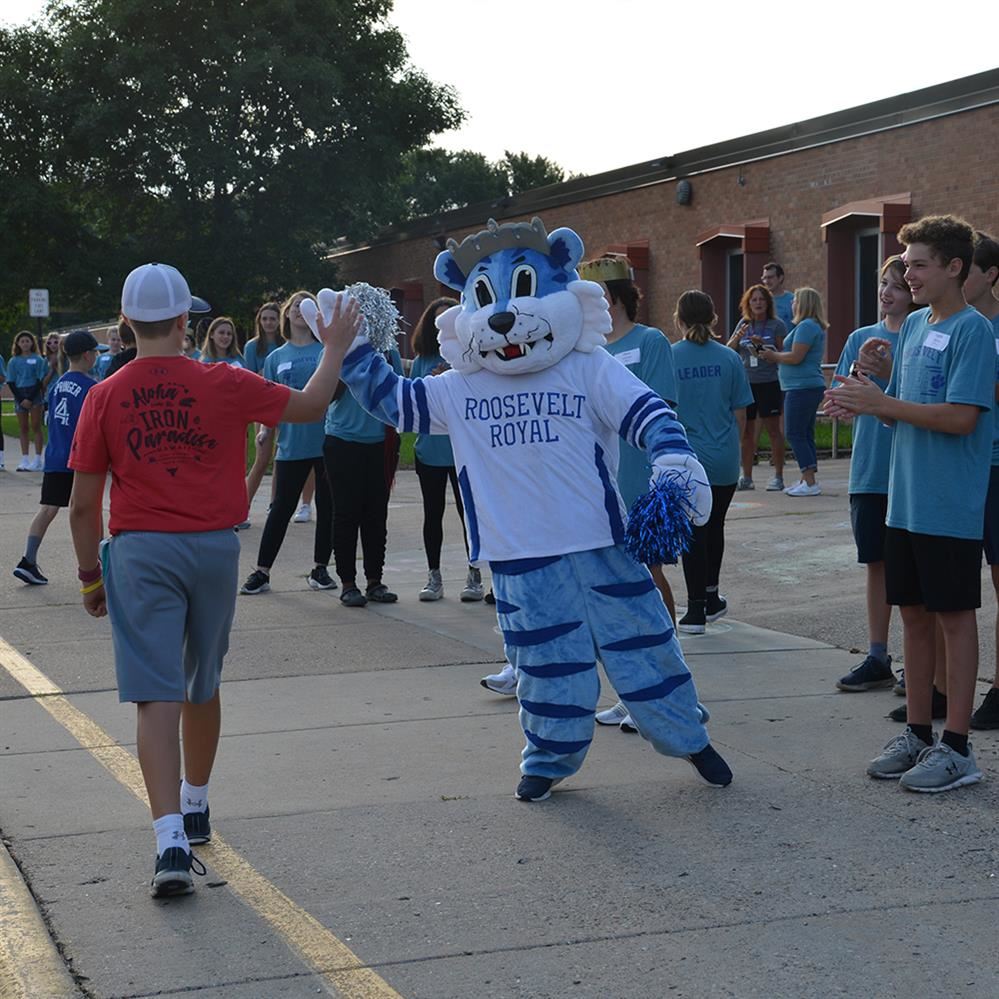  mascot giving high-five to 6th grader